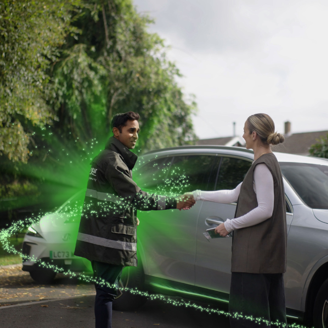 Man and woman shaking hands next to car