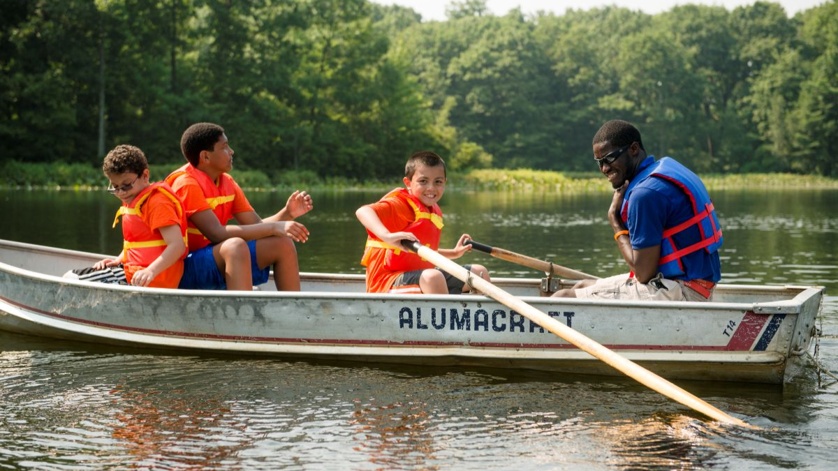 Couselors and campers on a rowboat ride at Pouch Camp.