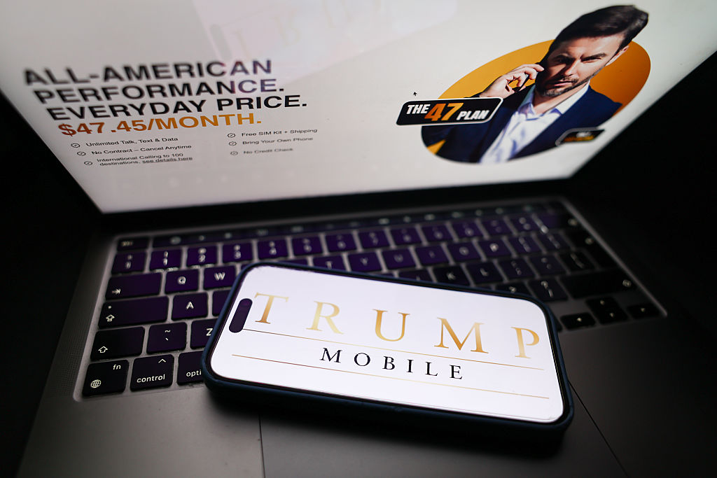  Photo illustration of a laptop and phone displaying the Trump Mobile website and logo